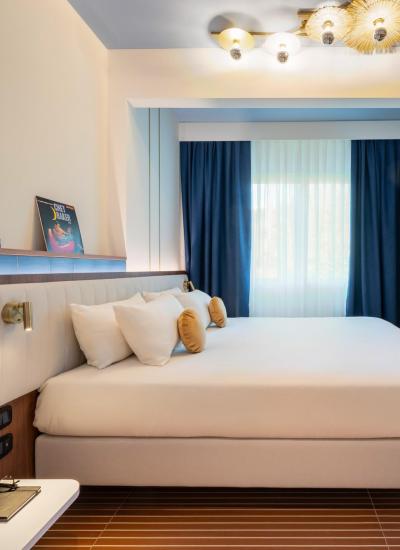 Camera moderna e luminosa con letto comodo e dettagli eleganti.
