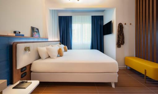 Moderne, helles Zimmer mit bequemem Bett und eleganten Details.
