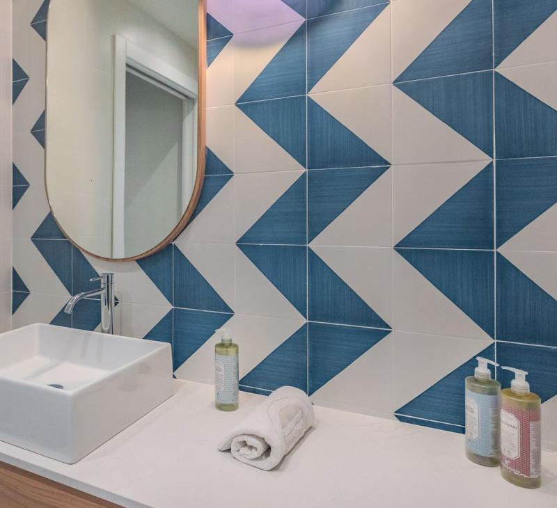 Modern bathroom with blue tiles and a square sink.