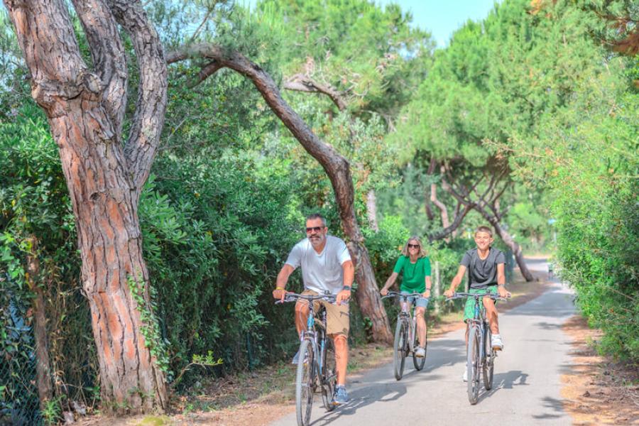Famiglia in bicicletta su un sentiero immerso nella natura.