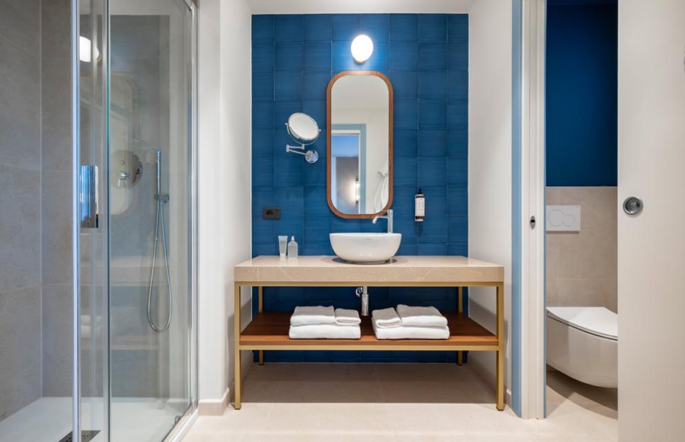 Modernes Badezimmer mit blauen Wänden und eleganten Details, entspannende Atmosphäre.